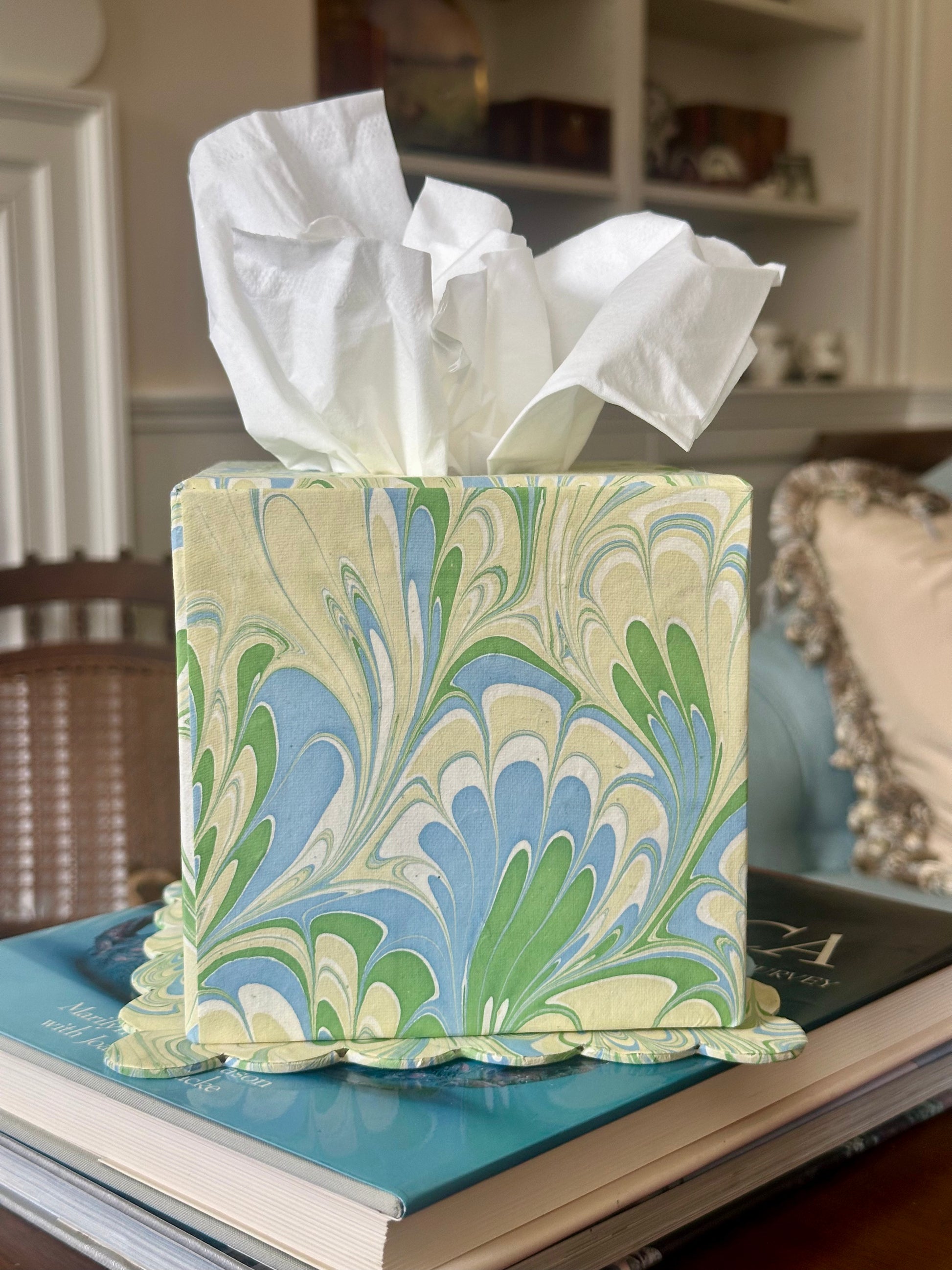 Marbled tissue box cover with tissues on a surface